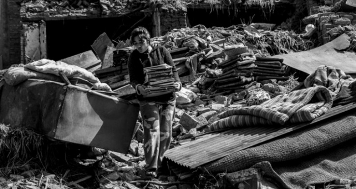 A young girl salvages books from her collapsed house in Harisiddhi a week after the earthquake